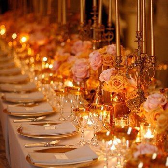 A long table adorned with gold and pink flowers