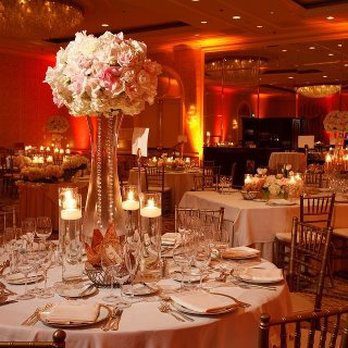 A wedding banquet room with elegantly arranged tables and chairs for a reception celebration